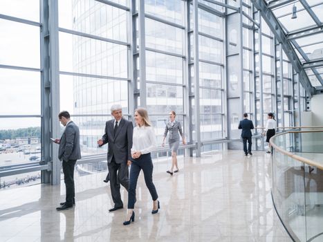 Business people walking in a modern hall of office building
