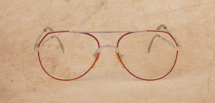 Vintage glasses, broken, isolated on a old brown background