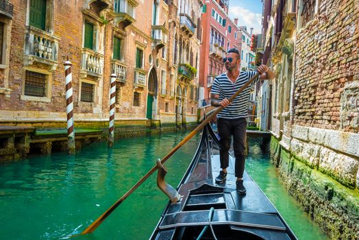 Handsome gondolier during gondola ride on the street of Venice, Italy