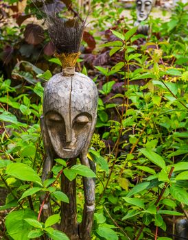 wooden aboriginal sculpture, traditional african decorations for the garden, nature background