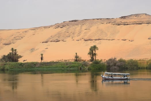 The beginning of the Sahara Desert With the Nile in the foreground taken in Aswan Egypt with Nile River Boat