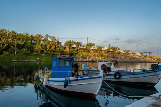 Fishing boat and a fisherman with a dog in the port of Sissi, Crete, Greece.