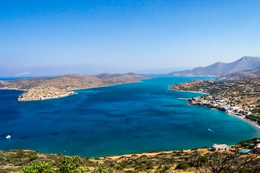 Seascape. Panoramic, picturesque view of the city resort Elouda (Greece, island Crete) mountains and the sea from the height on a sunny evening.
