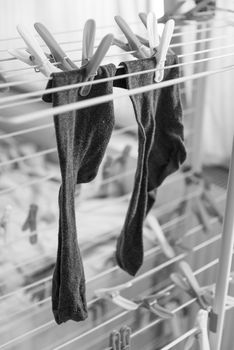 Drying socks are hanging on the clothes dryer with clothespin, black and whyte creative, concept photo