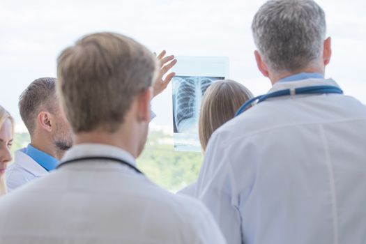 Group of doctors look and discuss x-ray in a clinic or hospital