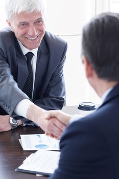 Business people shaking hands at meeting table