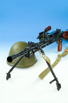Machine gun and flowers in an army helmet