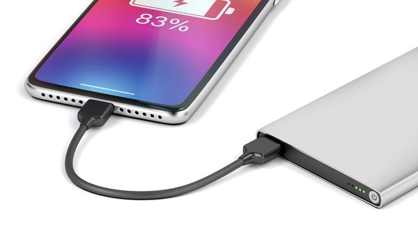 Smartphone charging with silver power bank, close-up