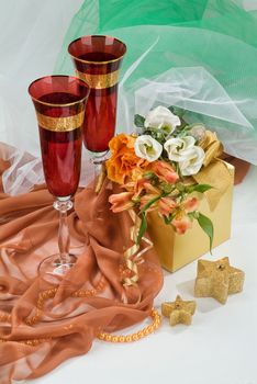 Glasses with wine on a decorative fabric background