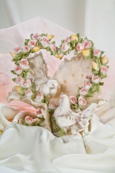 Heart shaped bouguet and toy pigeons on a fabric background