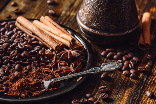 Spoonful of Ground Coffee, Coffee Beans and Some Spices on Plate.