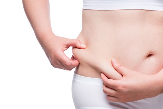 fat woman measures the layer of subcutaneous fat on the abdomen, closeup belly isolated