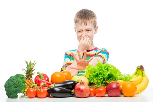 The boy does not like vegetables and fruits, disgust for food concept photo isolated
