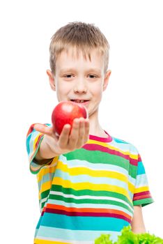 Portrait of a boy with a red ripe apple in the studio on a white background is isolated