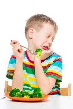 Emotional portrait of a child who does not like broccoli, the portrait is isolated