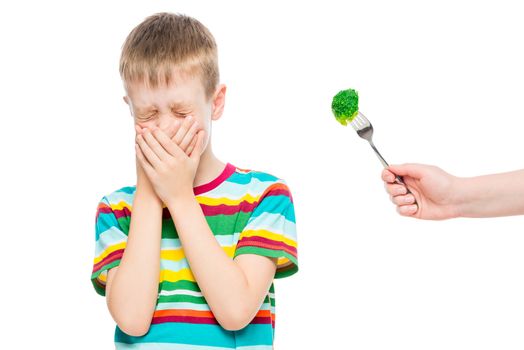 boy refuses serving healthy broccoli, emotional portrait of a child isolated on white background