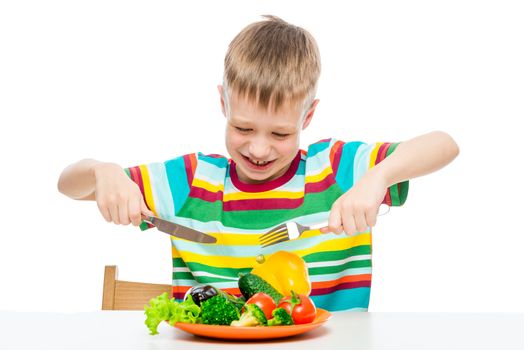 hungry boy 10 years old with a plate of vegetables, concept photo diet and healthy food