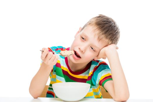 boy eating porridge, portrait of a child isolated on white background