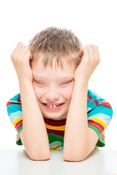 vertical emotional portrait of a boy of 10 years at the table on a white background isolated