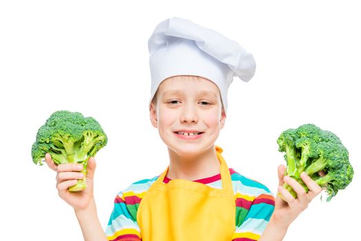 horizontal portrait of a boy in a cook hat with broccoli on a white background