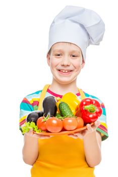 boy cook in a cap with a plate of ingredients - healthy vegetables on white background