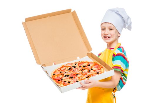 portrait of a child cook in a cap with a pizza in a box on a white background in the studio