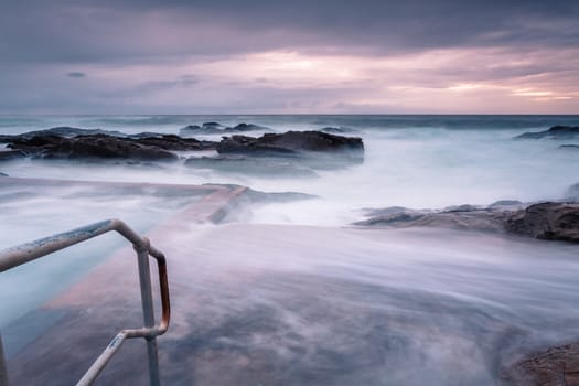 Large waves and swell engulf the public rock pool.  Long exposure  creates a mystical feel of what was a tempestuous ocean