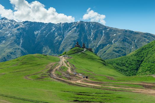 Scenic view of the Trinity Church on the background of the snow-capped peaks of the Caucasus in Georgia