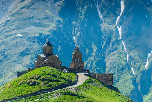 Georgia, Trinity Church on the mountain against the background of rocks in the village of Gergeti on the Georgian Military Highway