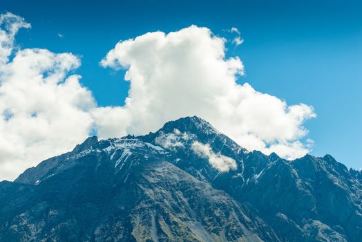 high mountain peaks and clouds, a beautiful mountain landscape on a sunny day. Caucasus, Georgia