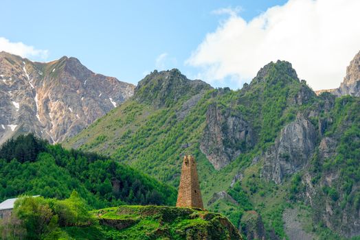 High traditional tower of Georgia on the background of high mountains of the Caucasus