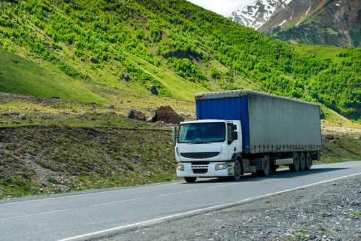 Wagon transports cargo on a mountain road in a picturesque place in the Caucasus