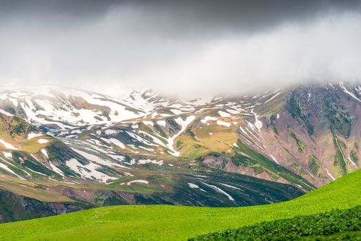Scenic mountains with snow in June, Caucasus landscape on an overcast day, Georgia