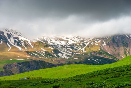 Beautiful relief mountains with snow in June, Caucasus landscape on a cloudy day, Georgia