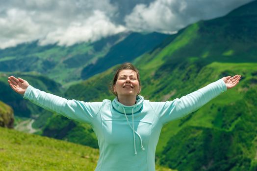 Portrait of a happy woman enjoying freedom in traveling in the mountains