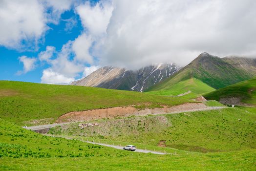 A car on the Georgian Military Highway, a beautiful mountain road of Georgia, the Caucasus in summer