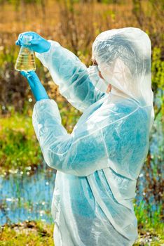 Vertical portrait of an environmentalist in protective clothing during work - lake water research