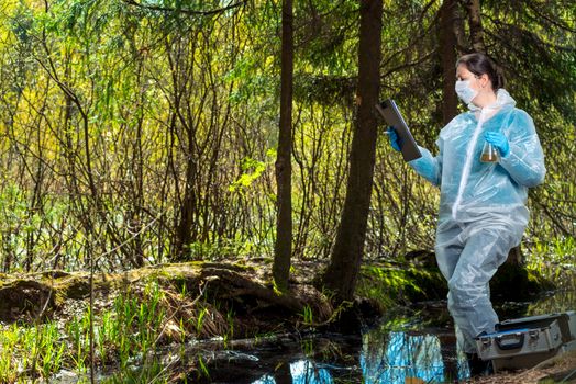 an experienced researcher studies the properties of water from a forest river