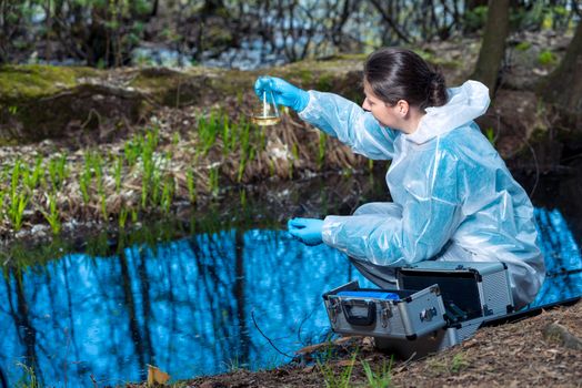 water sample from a forest river in a flask in the hands of an ecologist biologist