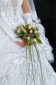 Woman's hands with bouquet of flowers on a black background