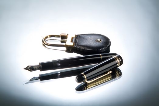 Keychain and pen on a glass studio background