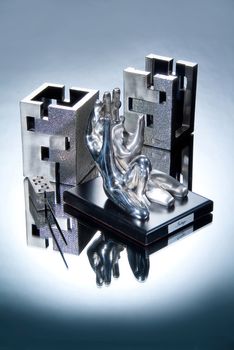 Metal statuettes on a glass studio background