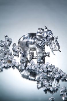 Metal elephant statuette on a glass background
