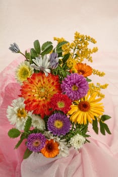 Still life with bouquet of flowers and accessories on a studio background