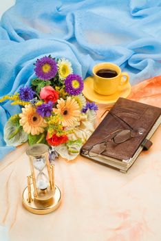 Still life with bouquet of flowers and accessories on a studio background