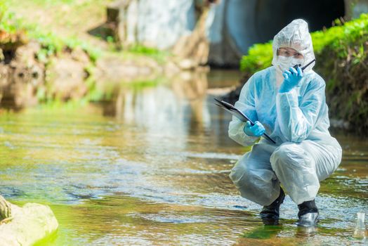 portrait of a scientist with a walkie talkie and a notepad on the background of the river