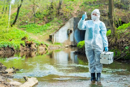 Ecologist with sample of water collected in lake