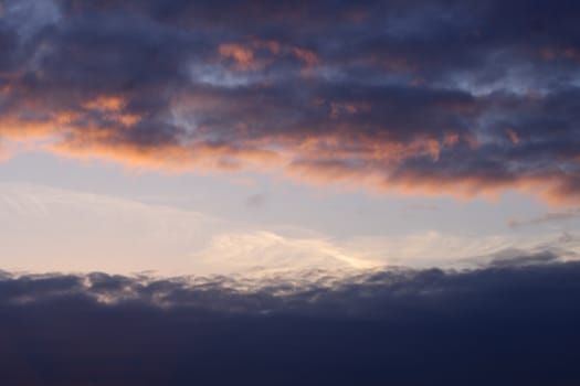 Red evening sunset above the lake or river. Purple and blue clouds and falling sun