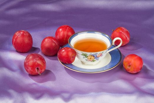Cup of tea and apricots on a fabric studio background