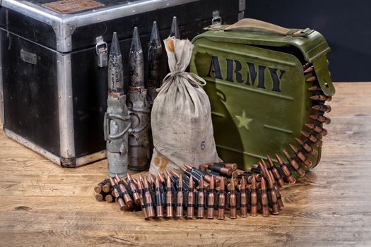 Still life of military armament, weapon and cartridges on wooden background